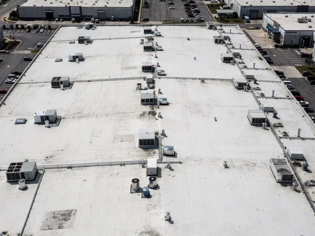 Aerial view of large commercial flat roof with HVAC units showing building size and scale